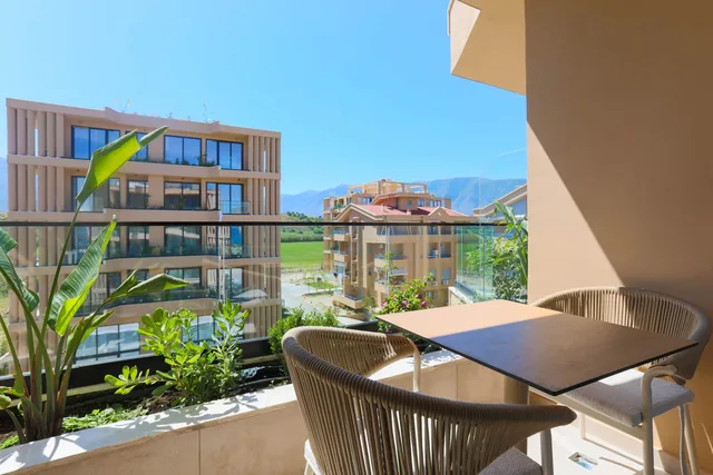 Balcone con tavolo e poltroncine, verde e montagne sullo sfondo